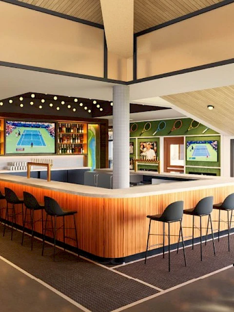A stylish indoor bar area with tennis-themed decor, multiple TVs showing tennis matches, and seating for guests to relax.