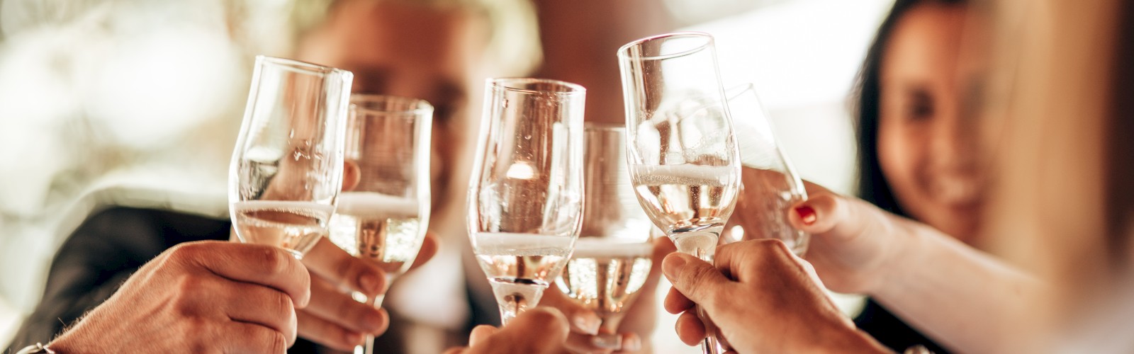 People are toasting with wine glasses, suggesting a celebration or gathering.
