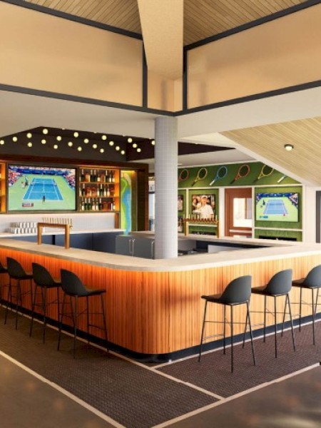 A modern indoor sports bar with tennis-themed decor, multiple screens showing tennis, and a wooden bar with black stools.