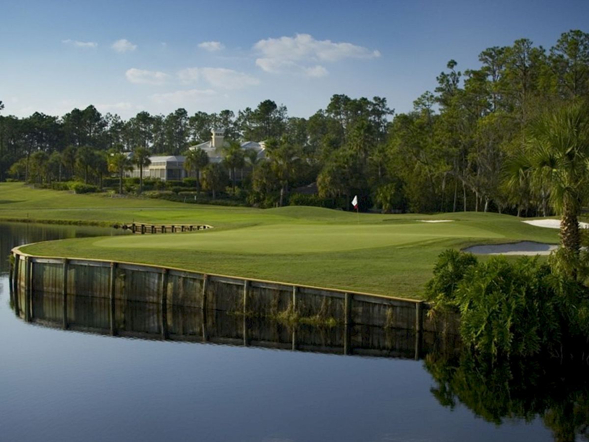 It's a scenic golf course with a green by the water, trees, and
