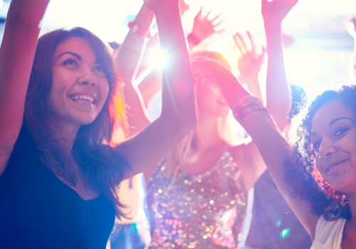 People dancing and having fun at a lively party with colorful lighting.