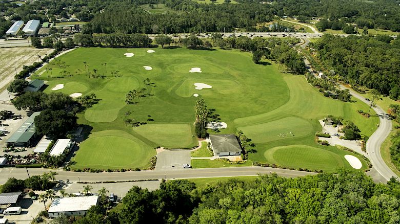 Aerial view of a golf course with lush greens, sand traps and trees