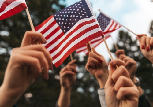 People holding small American flags outdoors.