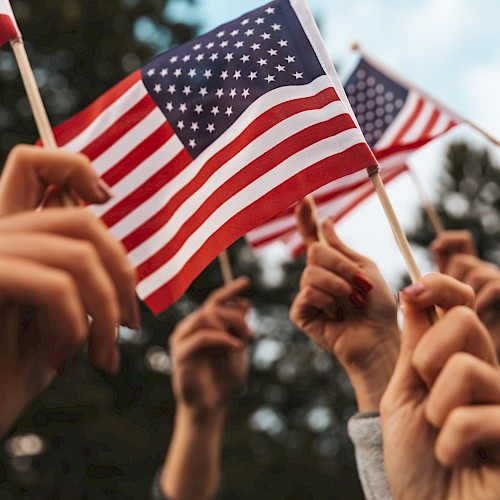 People holding small American flags outdoors.